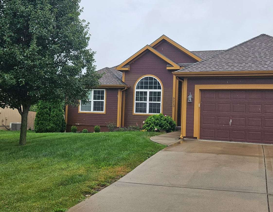 Before: maroon siding with gold trim and a maroon garage door