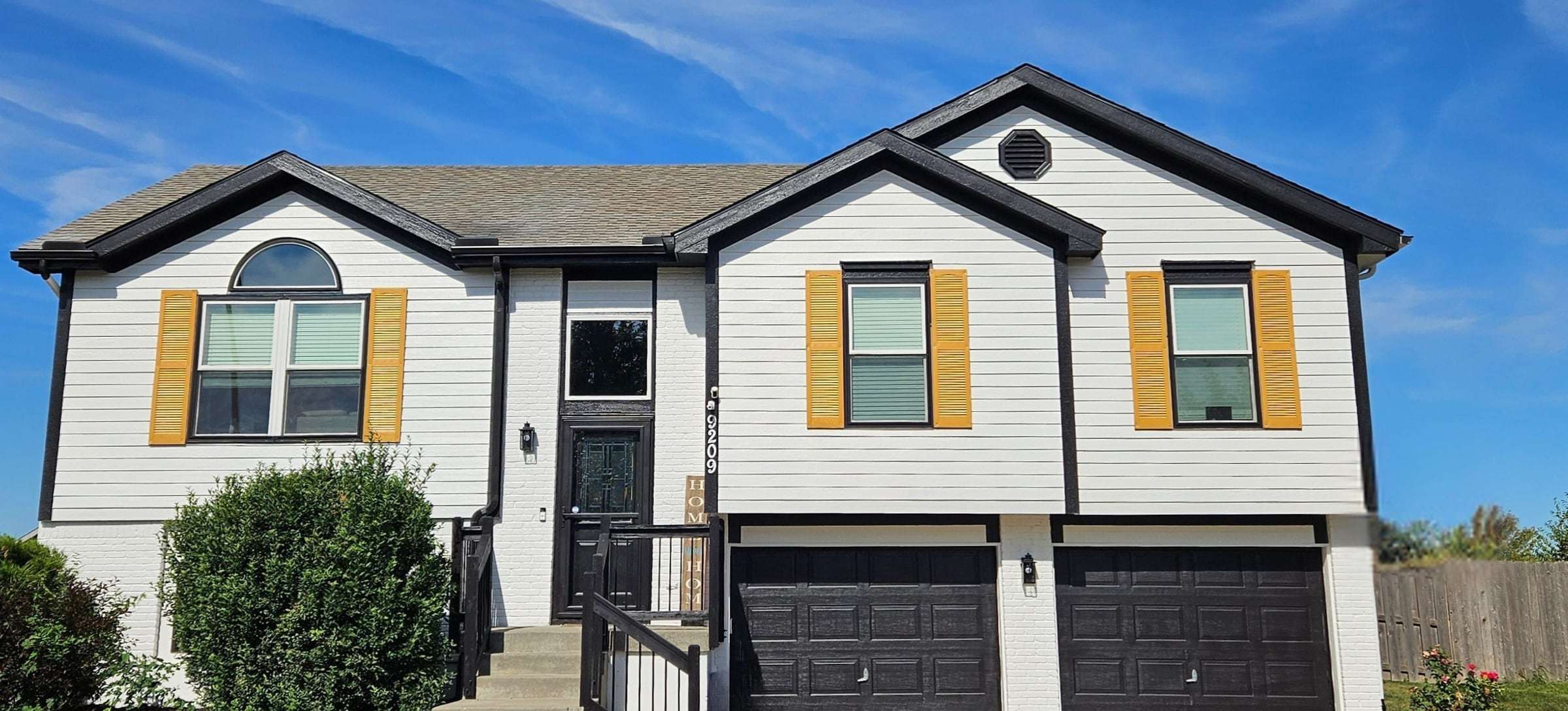 After: white siding, black trim and black garage doors